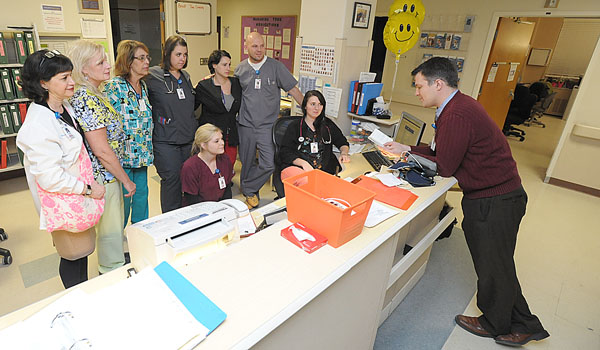 The Telemetry unit at Sisters of Charity Hospital gathers in a `prayer huddle` and takes a moment of quiet reflection in an otherwise stressful job. In the telemetry unit of a hospital, patients are often in critical condition and need constant monitoring and care. (Patrick McPartland/Staff Photographer)