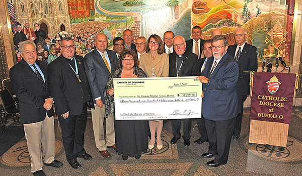 Cheryl Calire, center, director of Diocese of Buffalo Office of Pro-Life Activities stands with James Grubka, yellow tie, Grand Knight, Christ the King of Aurora Council #12829, Aimee Gomlak, center, Vice President of Women's Health Services, Catholic Health Systems and Bishop Richard Malone, among others, as they announce the generous donation of $15,957.60 from the Knights of Columbus to purchase state of the art handheld ultrasound machines for OBGYN centers operated by Catholic Health Systems. (Dan Cappellazzo/Staff Photographer)