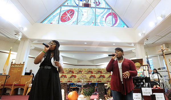 Desiree Moore (left) and Alaina Cottrell open the 2013 revival `Walk by Faith, Walk in Faith, Walk through Faith,` with song St. Martin de Poress Church. The revival is sponsored by the Diocesan African American commission and Office of Cultural Diversity, Diocese of Buffalo. (WNYCatholic File)