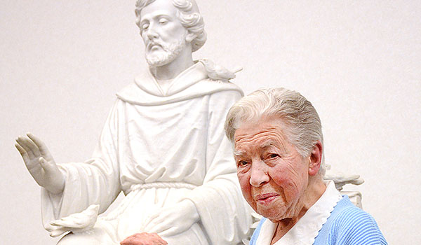 Sister Mary Helen Buscarino, OSF, a retired Franciscan who lives at St. Mary of the Angels Convent in Williamsville, stands with a statue of St. Francis of Assisi. (Dan Cappellazzo/Staff Photographer)