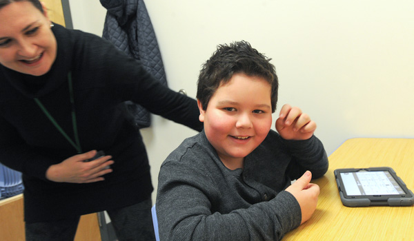 Lee Ann Terhune, a Cantalician Center speech therapist, works with 9-year-old Brayden Davis and his iPad at the Depew school. The speech therapy department is helping nonverbal children communicate with the help of the tablet computers. (Dan Cappellazzo/Staff Photographer)