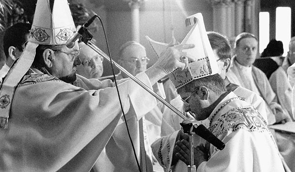 Bishop Edward Head places the mitre on the head of Bishop Edward M. Grosz during installation ceremonies at St. Joseph's Cathedral on February 2, 1990.