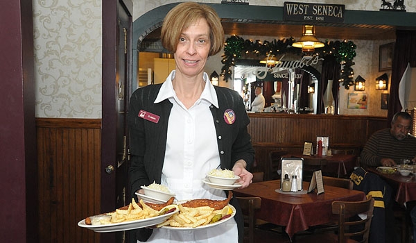 Waitress Debbie McGowan has her hands full with fish fry dinners at Schwabls restaurant in West Seneca. Schwabls serves their fish fry daily all year and the restaurant has been in business since 1837.
(Patrick McPartland/Staff Photographer)