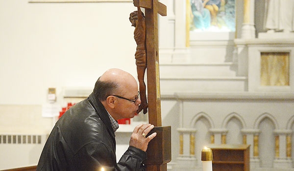A man kisses the feet of Christ during the veneration of the Holy Cross during Good Friday services at St. Joseph Cathedral
(Patrick McPartland/Staff Photographer)