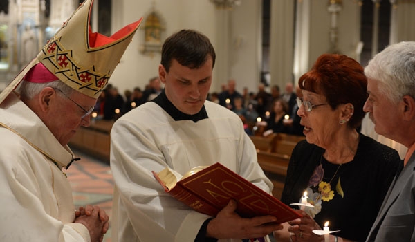 Beth Hoestermann (right) is received into full communion with the Church by Richard J. Malone during the Easter Vigil Mass at St. Joseph Cathedral. (Patrick McPartland)