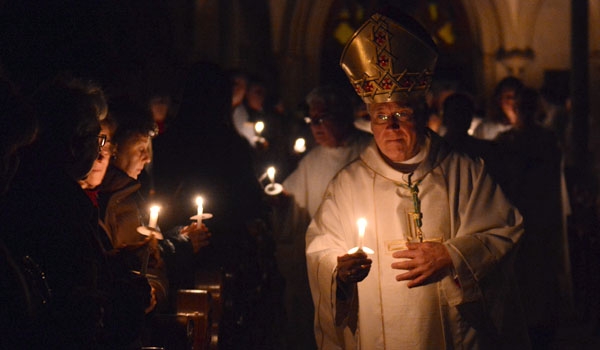 Bishop Richard J. Malone processes and lights other candles during the Easter Vigil Mass at St. Joseph Cathedral. (Patrick McPartland)