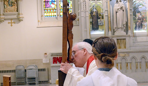 Bishop Richard J. Malone kisses the feet of the crucifix during the adoration of the Holy Cross as part of  Good Friday services at St. Joseph Cathedral
(Patrick McPartland/Staff Photographer)
