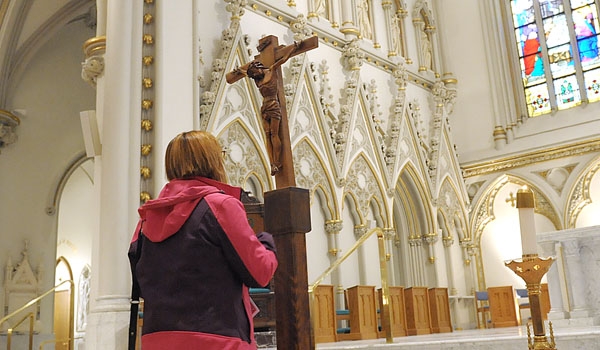 A woman pauses to venerate the Holy Cross at the conclusion of Good Friday services at St. Joseph Cathedral
(Patrick McPartland/Staff Photographer)