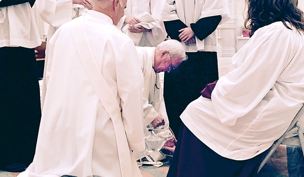 Bishop Richard J. Malone washes the feet of the faithful during Mass of the Lord's Supper at St. Joseph Cathedral. (Gregg Prince)