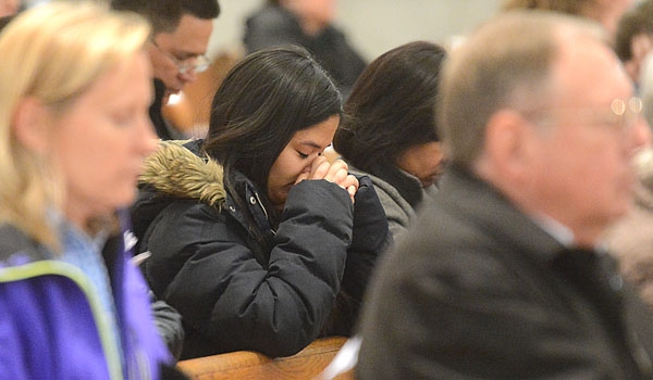 A woman silently prays during Good Friday services at St. Joseph Cathedral
(Patrick McPartland/Staff Photographer)