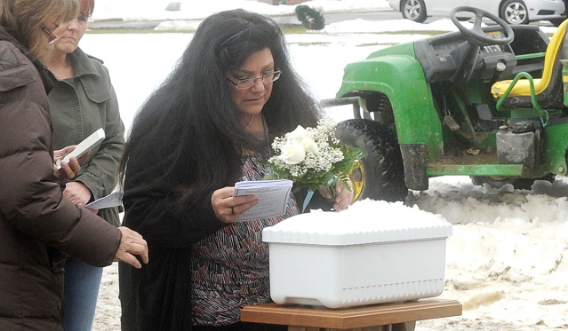 Cheryl Calire places flowers on the casket of 