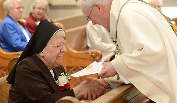 Bishop Richard J. Malone congratulates Sister Mary Thomas Frys, CSSF, for her 65 years of religious service. Women and men religious came together to celebrate their jubilees and the Year of Consecrated Life at St. Joseph Cathedral.
(Patrick McPartland/Staff Photographer)