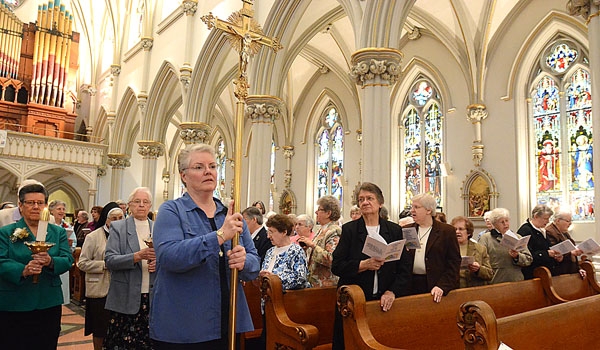 Sister Nora Sweeney, DC, carries the cross in the opening procession celebrating Jubilee 2015 and the Year of Consecrated Life at St. Joseph Cathedral.
(Patrick McPartland/Staff Photographer)