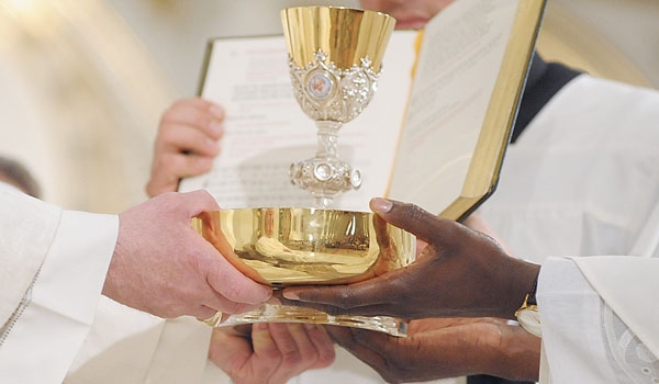 Bishop Richard J. Malone presents Daniel Ogbeifun with the bread and wine during his ordination to the priesthood. The ceremony took place at St. Joseph Cathedral.
(Patrick McPartland/Staff Photographer)