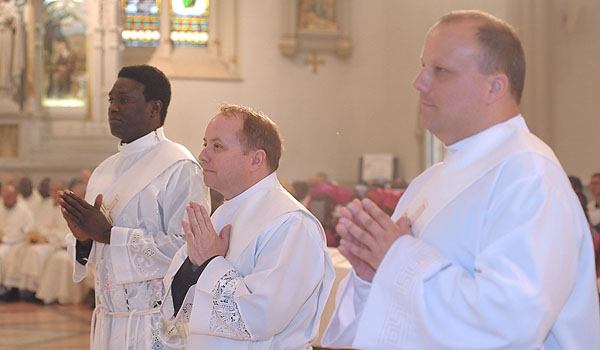Ordini Daniel Ogbeifun (left to right) Thomas Mahoney and Lukasz Kopala stand before Bishop Richard J. Malone during their ordination to the priesthood. The ceremony took place at St. Joseph Cathedral.
(Patrick McPartland/Staff Photographer)