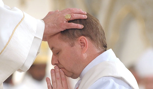 Bishop Richard J. Malone lays his hands on the head of Thomas Mahoney during Mahoney's ordination to the priesthood. The ceremony took place at St. Joseph Cathedral.
(Patrick McPartland/Staff Photographer)