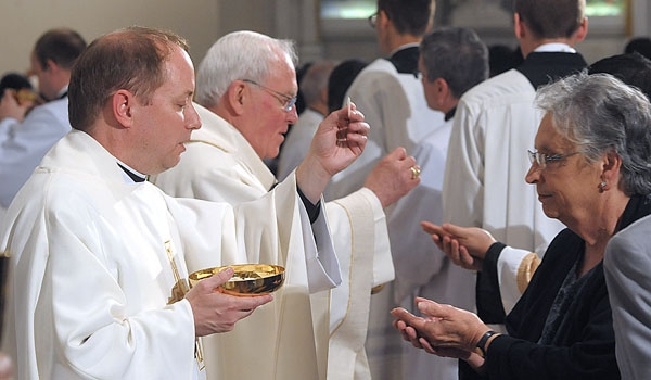 Father Thomas Mahoney takes part in Holy Communion after he was ordination to the priesthood. The ceremony took place at St. Joseph Cathedral.
(Patrick McPartland/Staff Photographer)