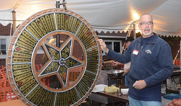 Mark Taylor spins the big wheel for prizes at the St. John Paul II Lawn Fete.