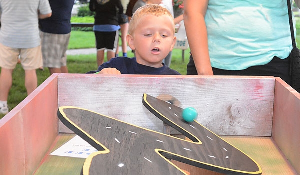 Four-year-old Maverick Kujawa tries to keep the ball on the road at the St. John Paul II Lawn Fete.
