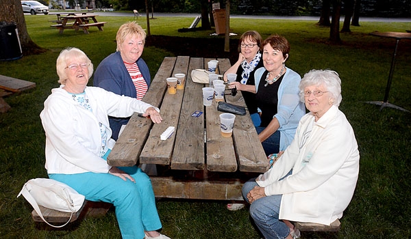 Marie Voltz (clockwise from bottom left), Mary Anne Smith, Doris Lawn, Kathy Bacon and Karen Shea gather around one of the picnic tables at the St. John Paul II Lawn Fete.
