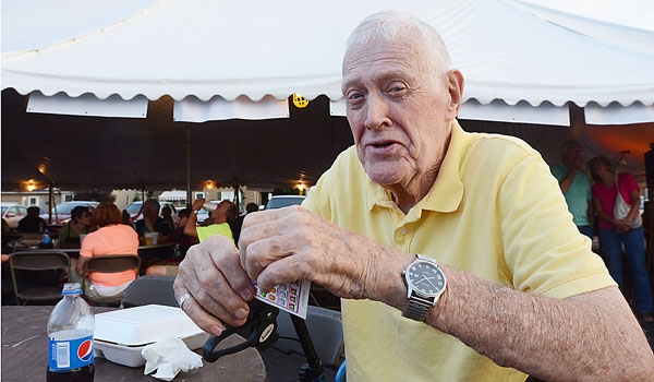 Parishioner Jim Maloney enjoys some food and Pull Tabs at the Our Lady of Charity Summerfest.
(Patrick McPartland/Staff Photographer)