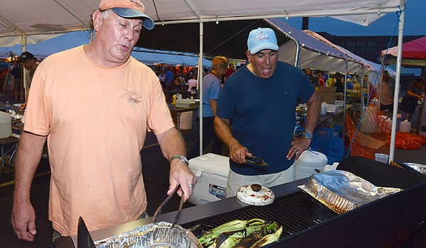 Cooks Frank Roman (left) and Sam Violanti brave the heat to serve delicious food at the Our Lady of Charity Summerfest.
(Patrick McPartland/Staff Photographer)