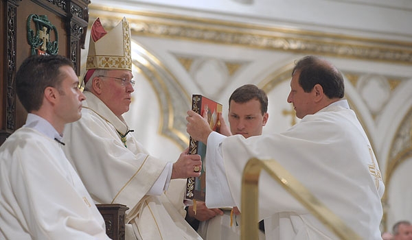 Transitional deacon Michael Brown receives the Book of the Gospels for Bishop Richard J. Malone during ceremonies for ordination to the diaconate at St. Joseph Cathedral.
(Patrick McPartland/Staff Photographer)