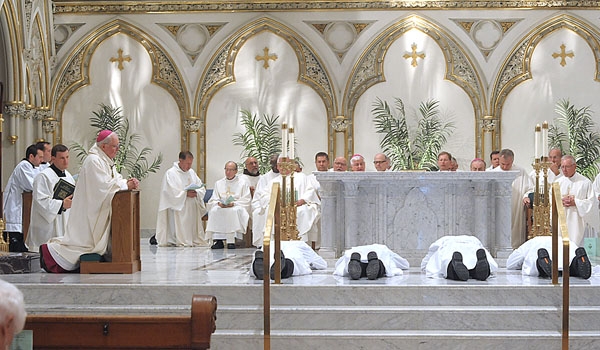 The four transitional diaconate candidates lay prostrate before the altar as the assembly joins in prayer invoking all the saints to ask the blessing of God upon them..
(Patrick McPartland/Staff Photographer)