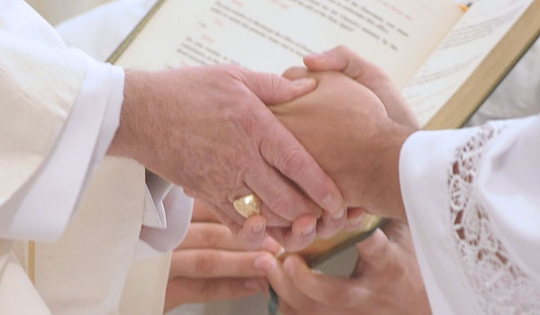 By placing his hands into the hands of Bishop Richard J. Malone, transitional deacon Michael LaMarca promises obedience and respect to the bishop.
(Patrick McPartland/Staff Photographer)