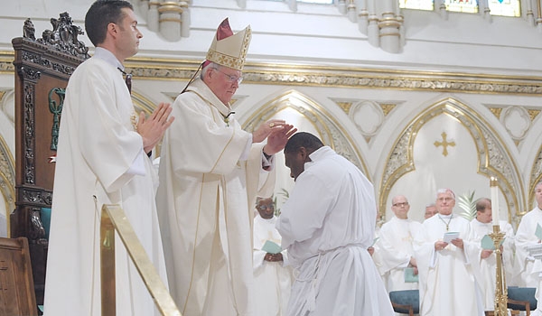 Bishop Richard J. Malone places his hands on the head of transitional deacon Venatius Agbasiere during ceremonies for ordination to the diaconate at St. Joseph Cathedral.
(Patrick McPartland/Staff Photographer)