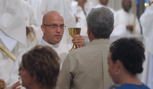 Transitional Deacon Michael LaMarca assists with Holy Communion during ceremonies for ordination to the diaconate at St. Joseph Cathedral.
(Patrick McPartland/Staff Photographer)