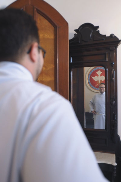 Transitional Deacon Samuel Giangreco checks how he looks in a mirror before ceremonies for ordination to the diaconate at St. Joseph Cathedral.
(Patrick McPartland/Staff Photographer)