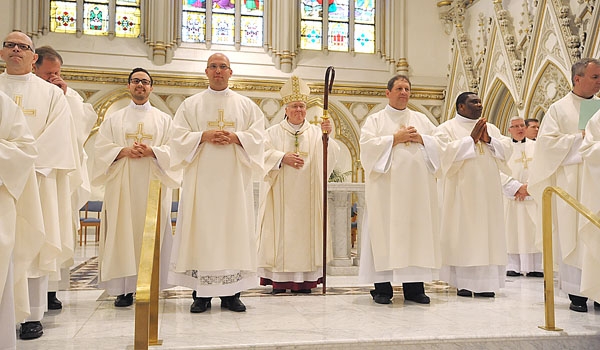 Four new transitional deacons stand before the assembly gathered at St. Joseph Cathedral.
(Patrick McPartland/Staff Photographer)