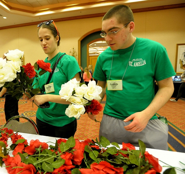 Carolyn Pudlewski and Francis Boeck from St. Amelia's Church create bouquets for the graves of priests and nuns at the 64th Annual Diocesan Youth Convention.