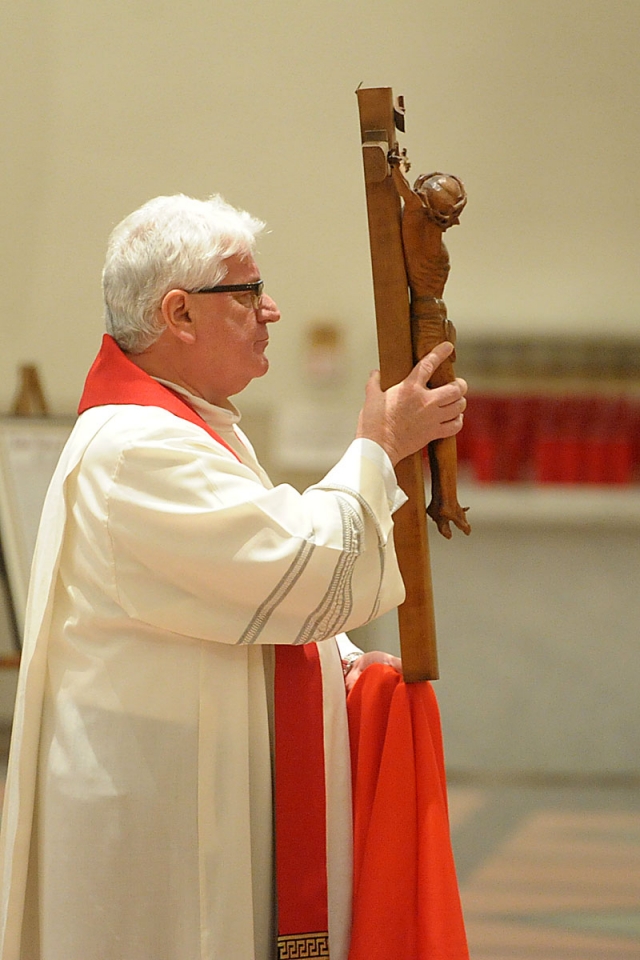 Msgr. David S. Slubecky, unveils the crucifix during the Good Friday celebration at St. Joseph Cathedral.