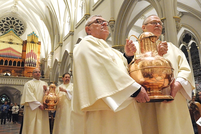 Urns containing the sacred oils are brought forth to the altar at St. Joseph Cathedral during the Chrism Mass.