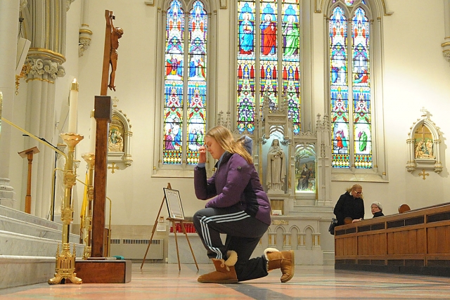 At the conclusion of Good Friday services at St. Joseph Cathedral, the faithful venerate the crucifix.