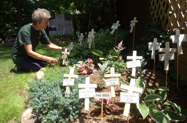 A special memorial display of the names of murder victims in the city of Buffalo from July 1, 2003 to June 30, 2004 is set up at the Peace Park of the Bissonette House.
Each victim has a cross with his/her name, age, day of death.
Sister Karen Klimczak, SSJ, coordinator of Hope House in Buffalo arranges some of the small crucifixes in the Peace Garden.