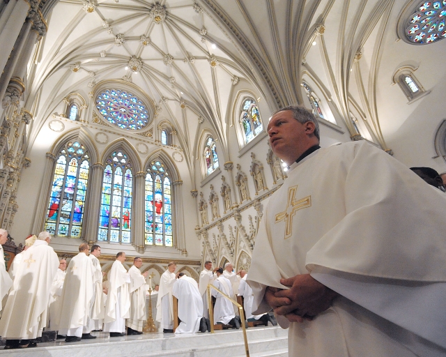 A long line of priests wait to impose hands on the heads of the newly ordained priests during ceremonies at St. Joseph Cathedral on May 28, 2016.
