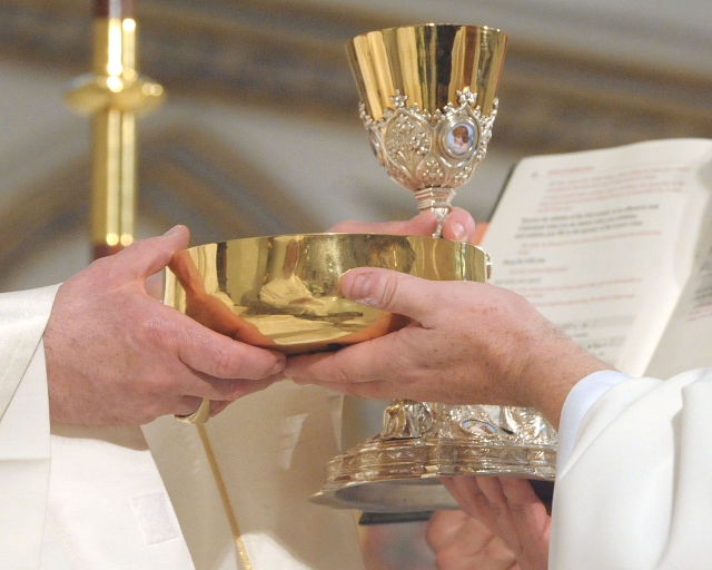 The bread and wine are handed to each ordinand during the Sacrament of Ordination ceremonies at St. Joseph Cathedral on May 28, 2016.
