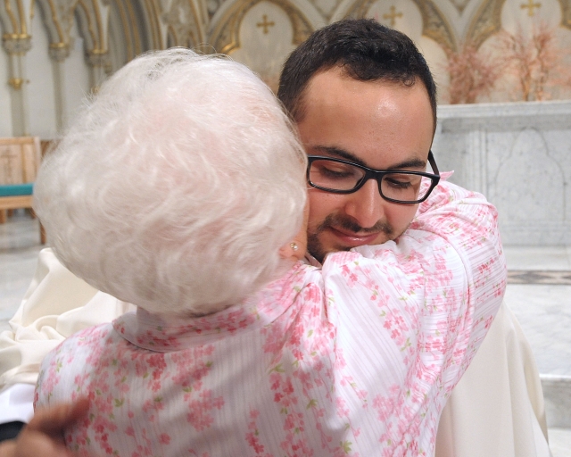 Father Samuel Giangreco receives a hung after being ordained to the priesthood at St. Joseph Cathedral on May 28, 2016.
