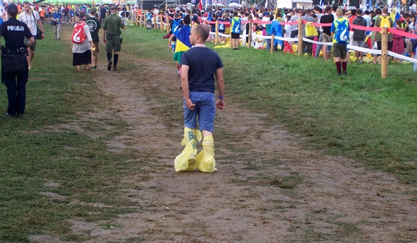 A thunderstorm earlier in the day left Blonia Park a little muddy. Some pilgrims attending the opening Mass had to innovate ways to stay dry. The opening Mass of World Youth Day 2016, celebrated by Cardinal Stanislaw Dziwisz and dozens of other clergy, to