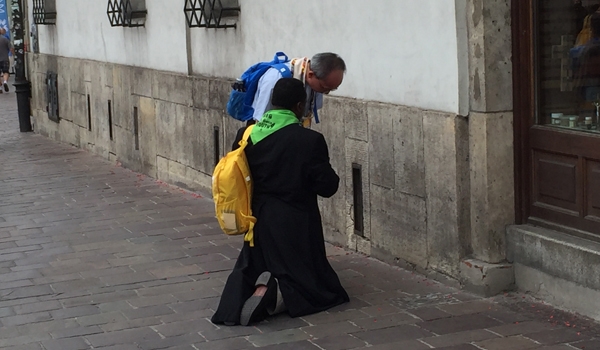 A priest stops to hear a confession on the streets of Krakow during World Youth Day. The city saw an influx of clergy who offered their services to the citizens and visitors during the weeklong Catholic event. (Patrick J. Buechi/Staff)
