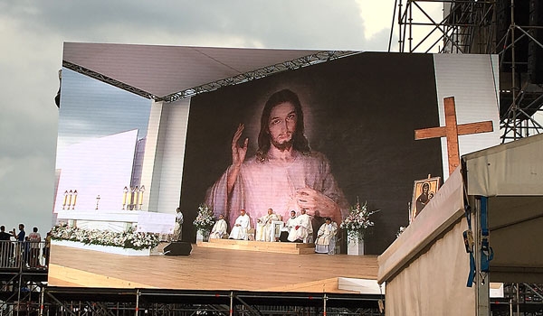 A copy of St. Faustian's Divine Mercy image serves as a backdrop for the opening Mass of World Youth Day 2016. The Mass, celebrated by Cardinal Stanislaw Dziwisz and dozens of other clergy, took place in Krakow's Blonia Park on July 26. (Patrick J. Buechi