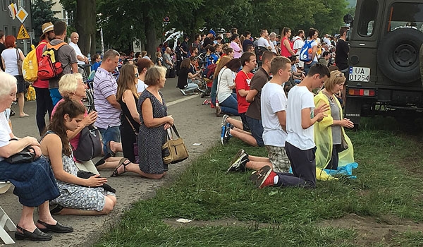 Pilgrims kneel in prayer during the opening Mass of World Youth Day 2016. The Mass, celebrated by Cardinal Stanislaw Dziwisz and dozens of other clergy, took place in Krakow's Blonia Park on July 26. (Patrick J. Buechi/Staff)