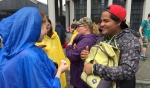 Victoria Erdman, from SS. Peter & Paul Parish in Williamsville, trades pins with a World Youth Day pilgrim from Mexico on the streets of Krakow during a rainy afternoon. (Patrick J. Buechi/Staff)
