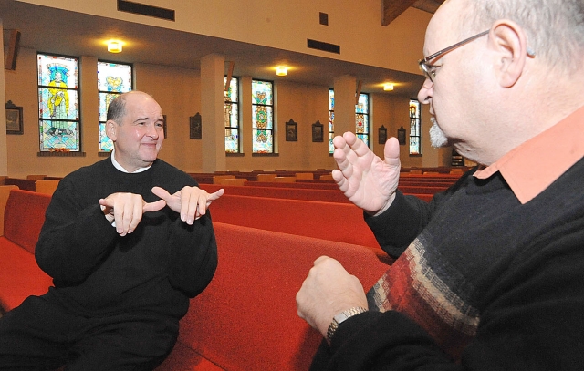 John Adams converses with Tom McGoo in Sign Language at Resurrection Parish, Depew. Adams will be ordained a Transitional Deacon and has been working with the Deaf Apostolate while studying at the Seminary.