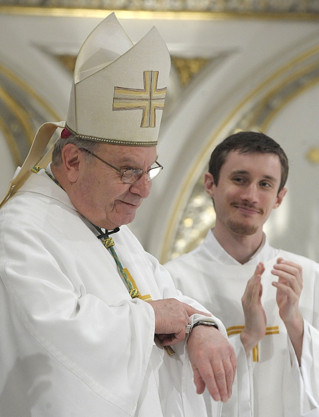 Bishop Edward U. Kmiec looks at his watch during a standing applause to indicate that the Mass was running long. The full Cathedral stood to applaud Bishop Kmiec's sever years as the shepherd of the Diocese.Chrism Mass celebration at St. Joseph Cathedral on April 19, 2011.