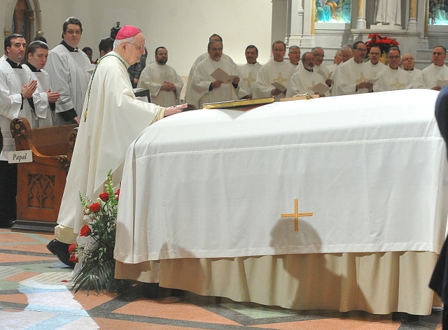 Bishop Emeritus of Erie, Bishop Donald Trautman, places his hand on the casket of Auxiliary Bishop Emeritus Bernard McLaughlin as Bishop Trautman enters St. Joseph Cathedral for a Mass of Christian burial for Bishop McLaughlin.