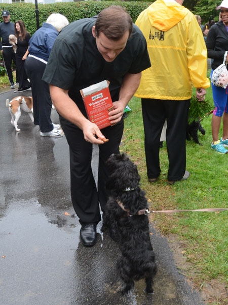 Father Ryszard Biernat, secretary to the bishop, gives Princess a dog treat after the pet blessing outside the bishop's residence to honor the feast of St. Francis of Assisi. 
(Patrick McPartland/Staff Photographer)
